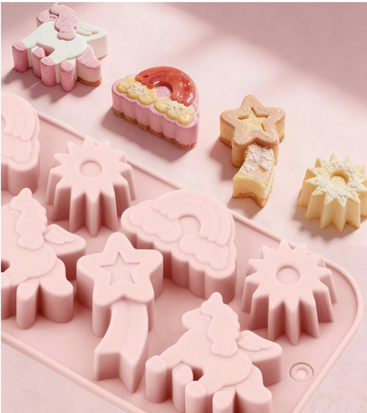 Pink silicone mold with unicorn, rainbow, star, and sun shapes, shown with several finished items in matching pastel shapes on a soft pink background.