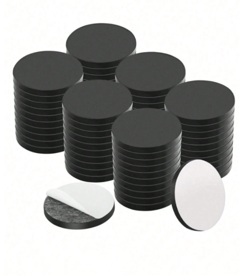 A set of round black adhesive magnets, shown in stacks.