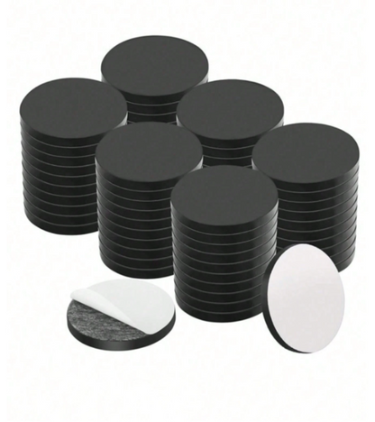 A set of round black adhesive magnets, shown in stacks.