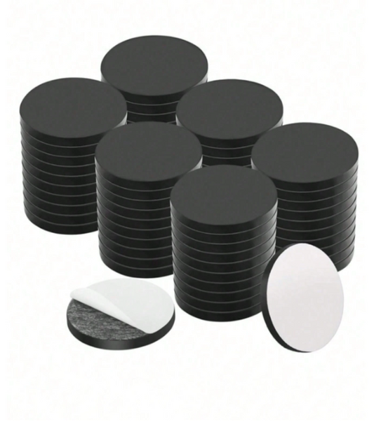 A set of round black adhesive magnets, shown in stacks.