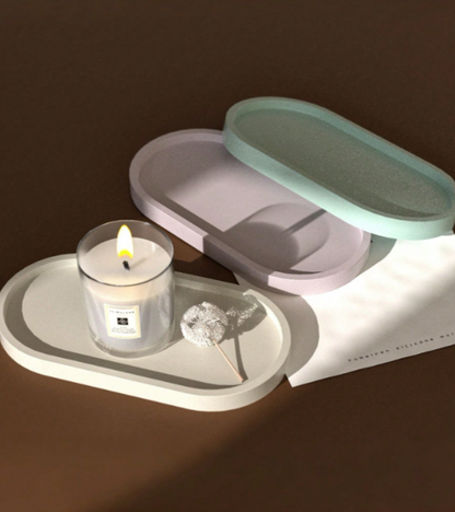 A set of minimalist pastel-colored oval trays in white, lavender, and mint green.