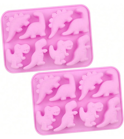 Two pink silicone baking molds with dinosaur-shaped cavities, displayed on a clean white background.