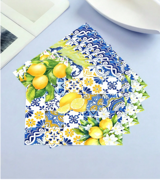 A stack of decoupage paper featuring a vibrant lemon and floral pattern, displayed on a light blue surface.