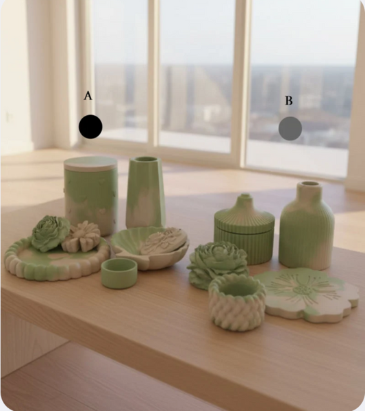 A set of light green and off-white ceramic tableware and vases arranged on a light wood table in front of large windows.