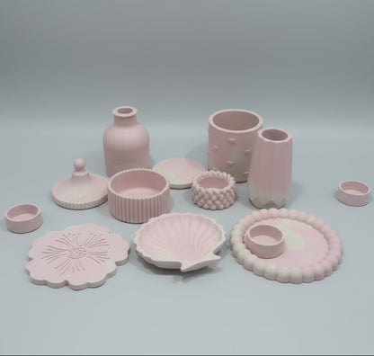 A collection of pastel pink ceramic pottery and decorative vases and storage jars